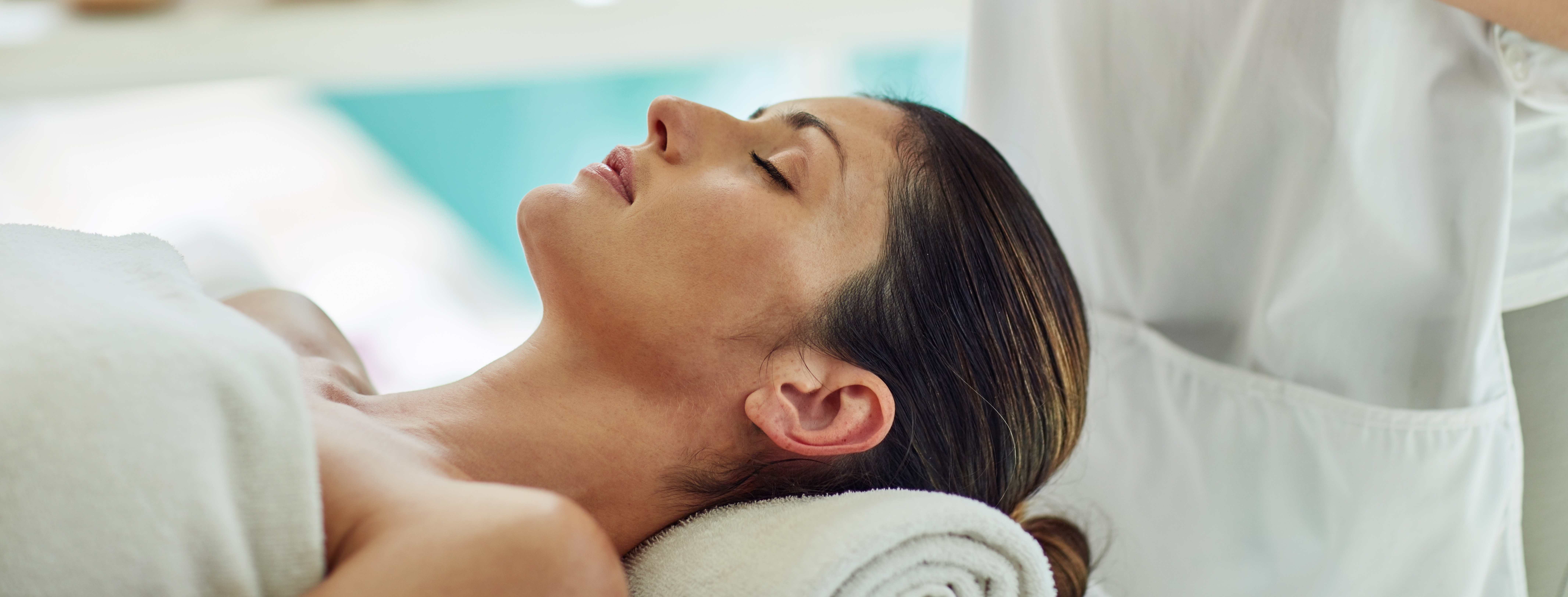 woman in towel laying down with towel under her head