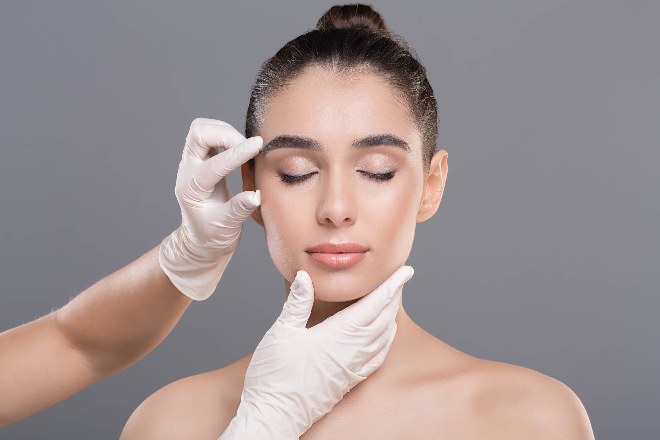 Image of a young woman getting cosmetic dermatology treatments on her face