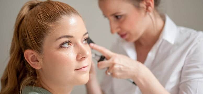 dermatologist doing a skin exam on young female patient