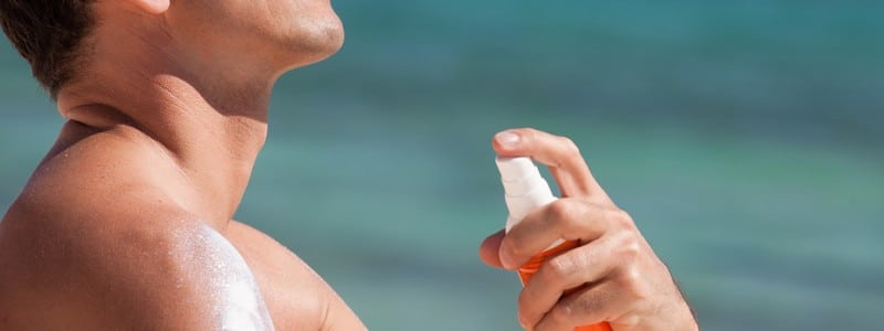 man at the beach applying protective cream